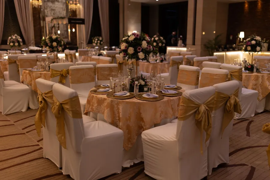 Salle de réception décorée, tables rondes et nappes dorées
